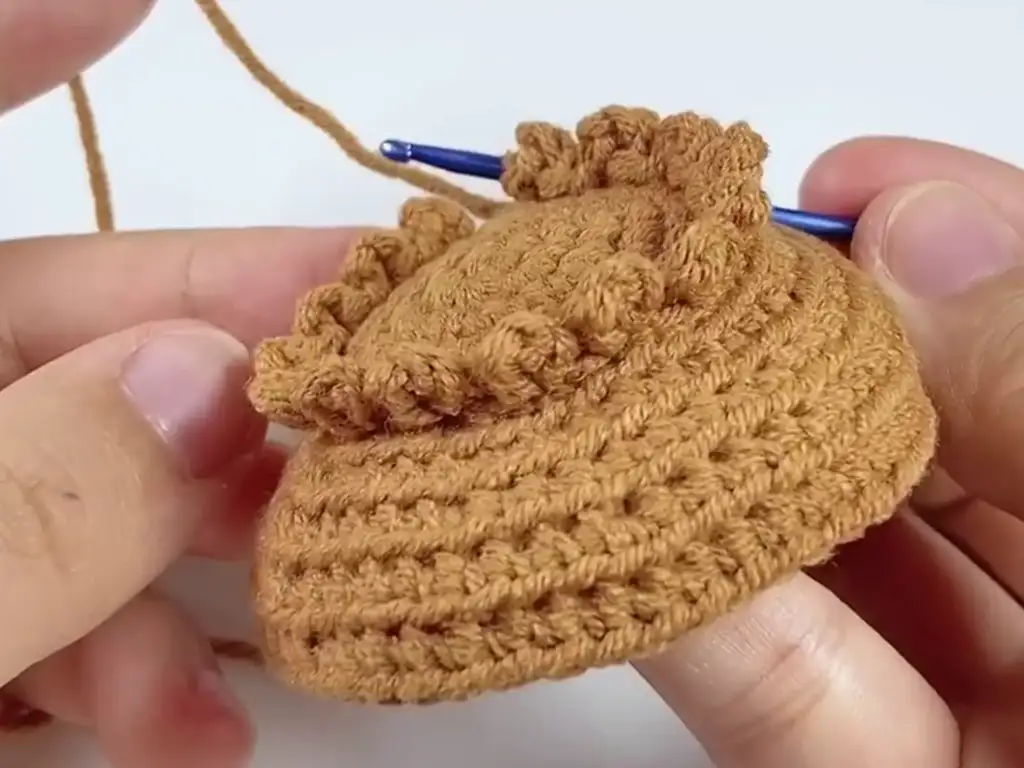 Adding texture to the crochet sunflower using the seed stitch technique.