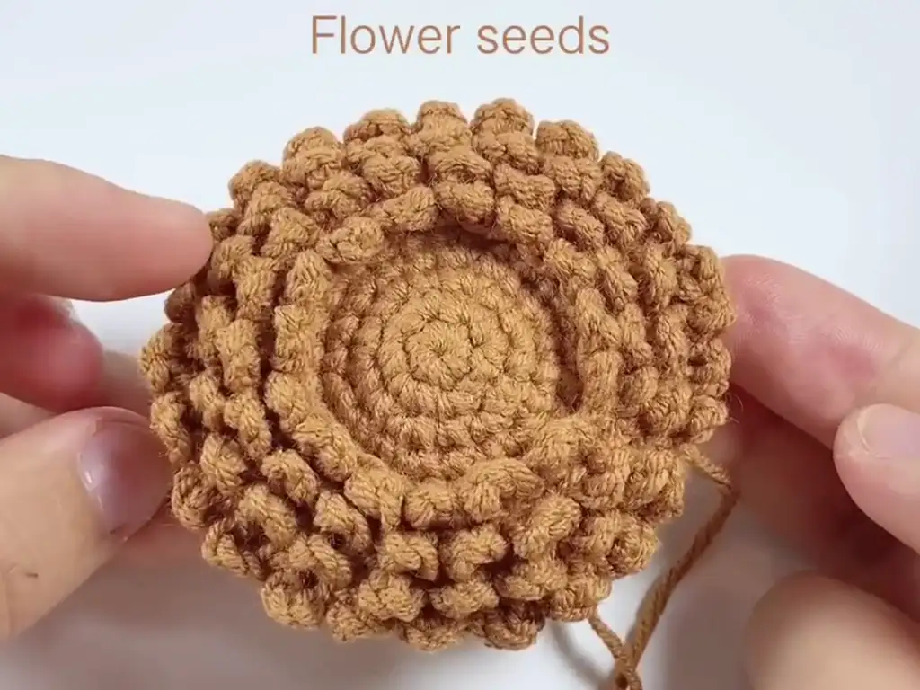 Adding texture to the crochet sunflower using the seed stitch technique.
