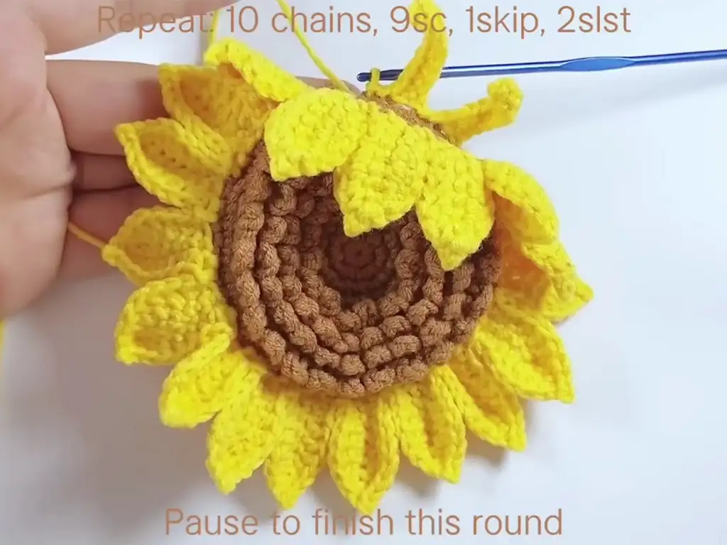 Attaching the second layer of petals to the crochet sunflower.
