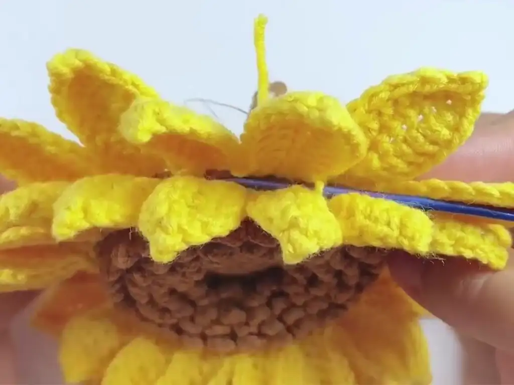 Attaching the second layer of petals to the crochet sunflower.