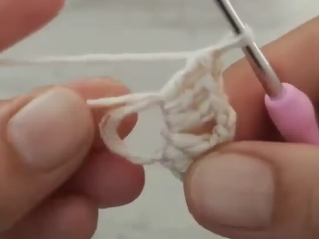 Close-up view of the stitch detail in crochet baby booties.