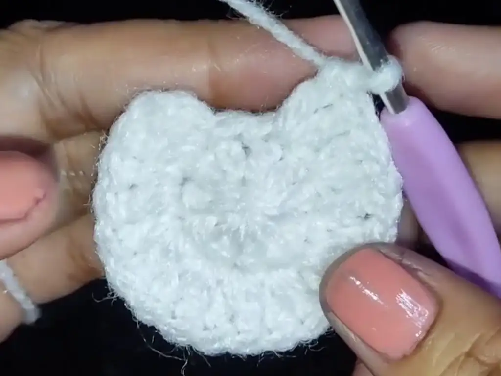 The chicken's body begins to emerge as we continue crocheting rounds and increasing stitches.