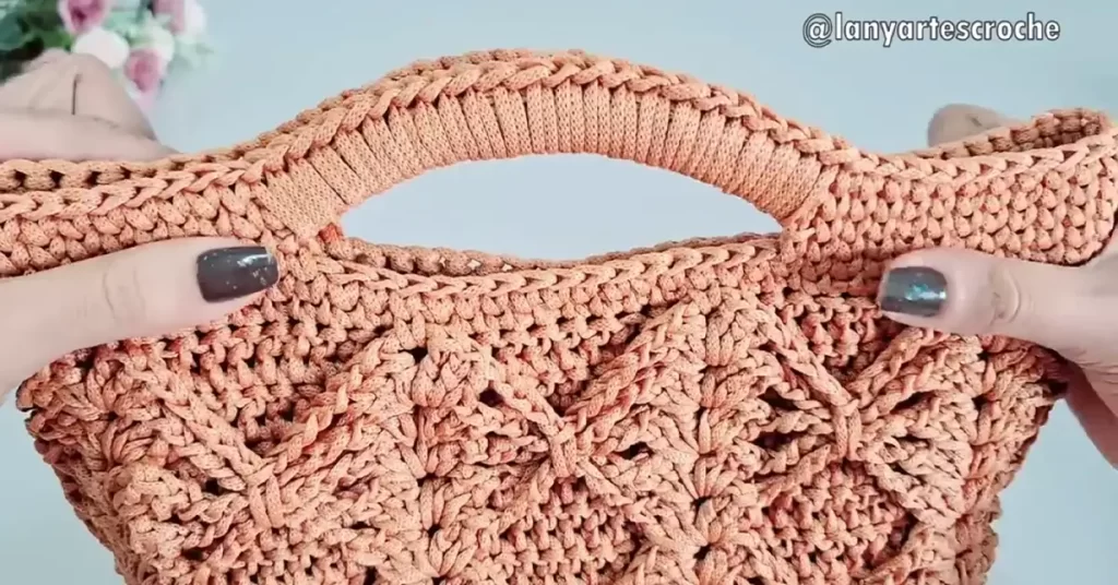 Close-up of the crocheted handle attached to the diamond stitch bag.