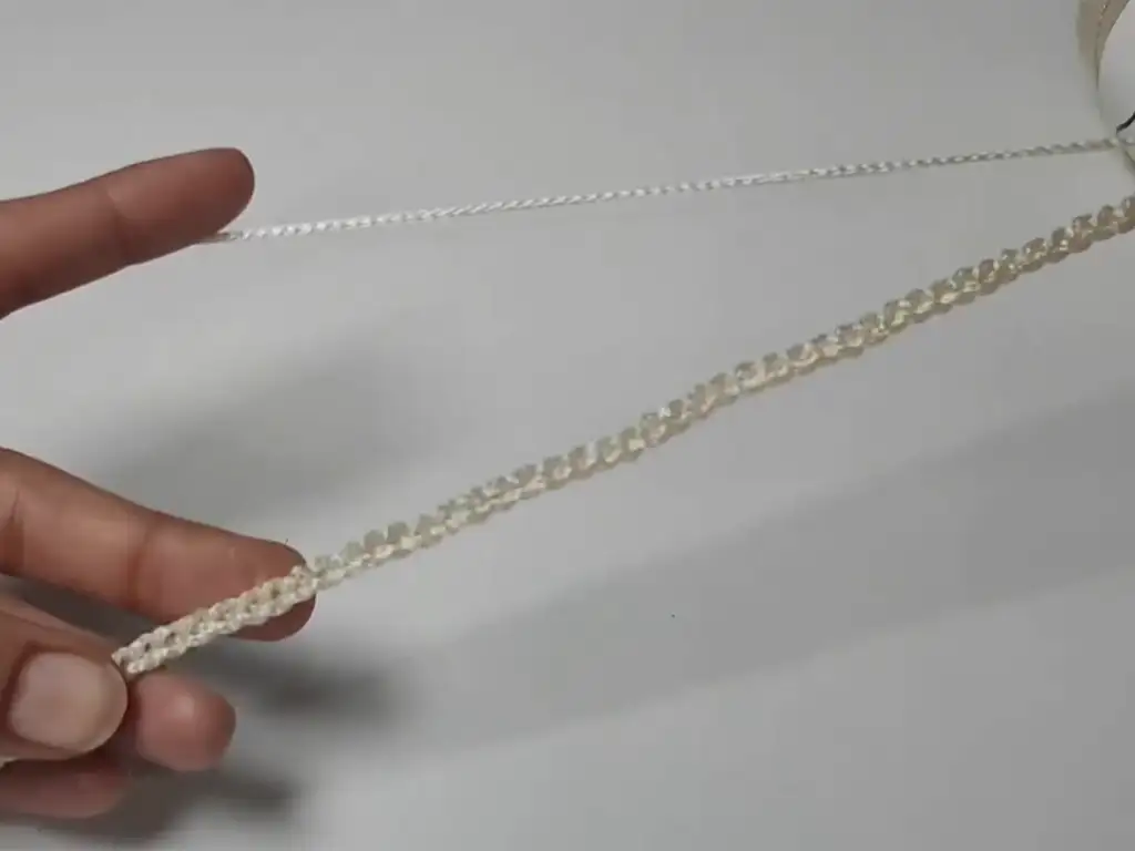 A long chain stitch created with cream-colored macrame yarn, the foundation for the tote bag pattern.