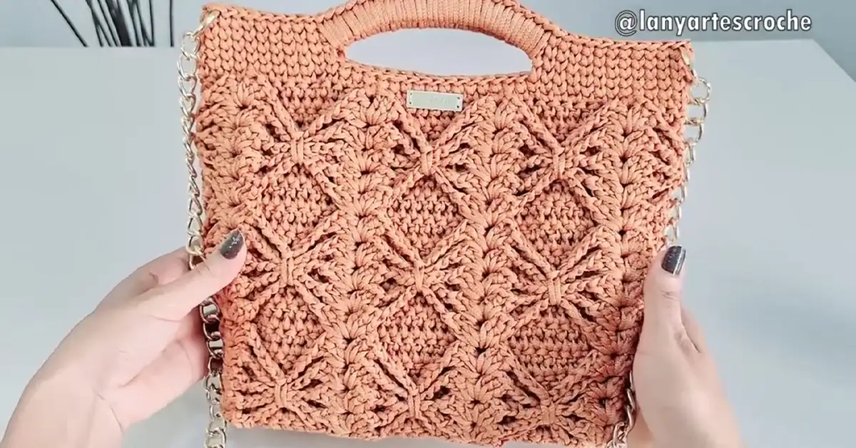 tylish crochet bag with a diamond stitch pattern, featuring a chain strap and a top handle.