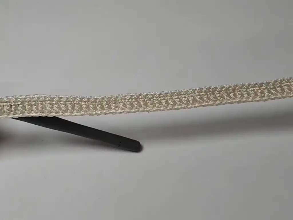 A row of double crochet stitches worked with cream macrame yarn, forming the base of the tote bag.