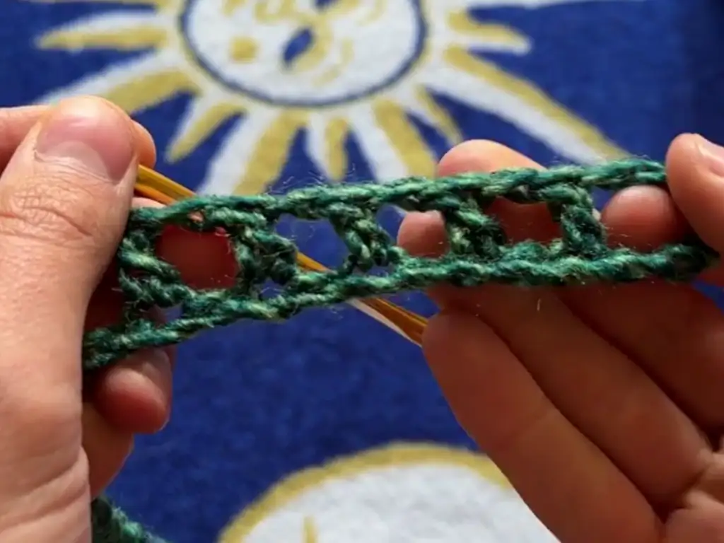 Close-up view of the crochet mesh stitch pattern used in the sleeves.