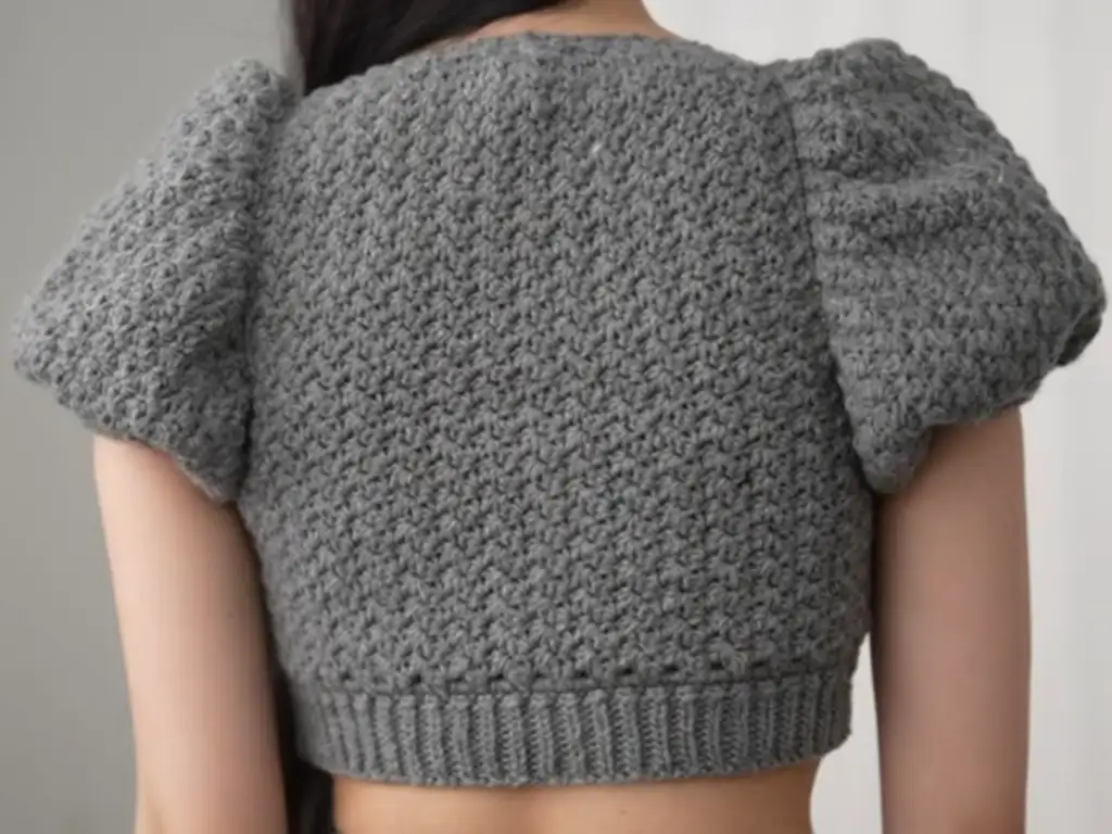 The completed crochet puff sleeve crop top, back view, with its textured stitch detail.