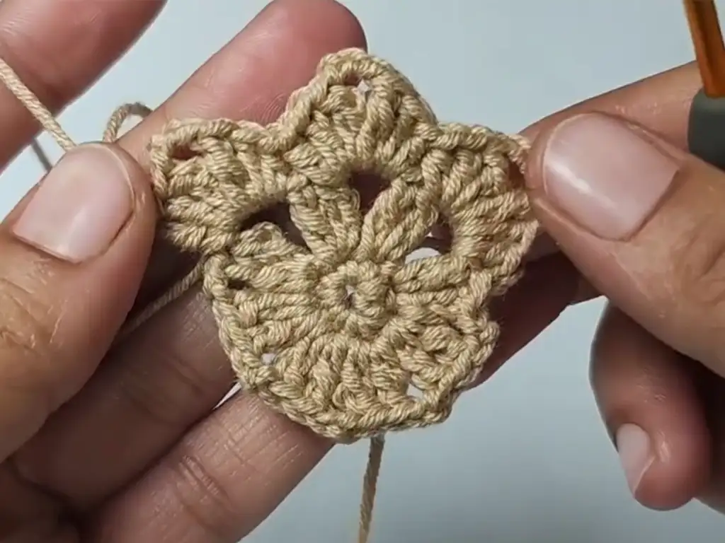 Crocheting the second round of the square, creating the initial shape.