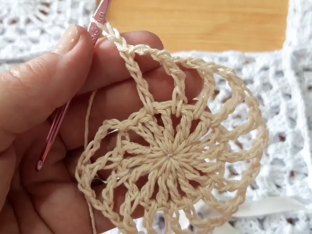 Detail of a granny square corner with chain spaces for a crochet top pattern.