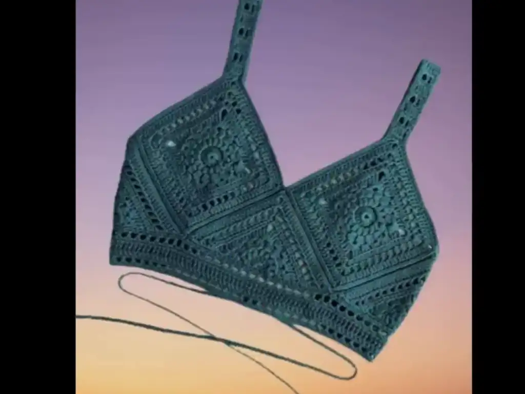 A teal crochet halter top with a unique tie closure and intricate granny square pattern.