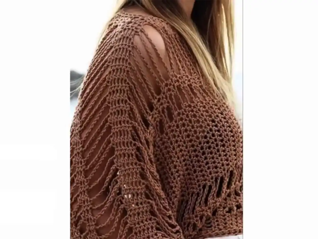 Crochet tunic with wide boat neck and open stitch design.
