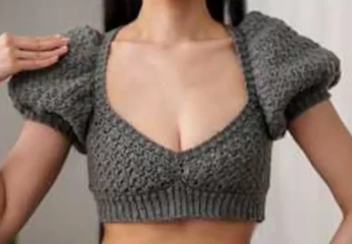 Stylish grey crochet crop top with puff sleeves, perfect for summer.