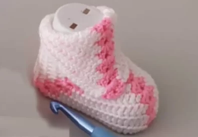 Pink and white crochet baby booties with a granny square design.