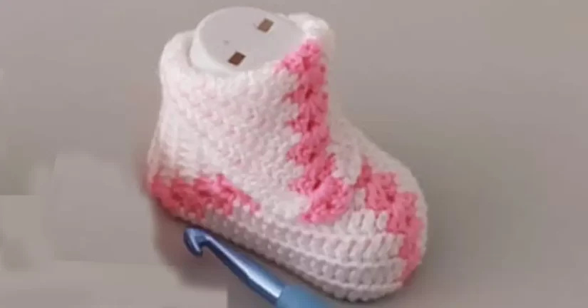 Pink and white crochet baby booties with a granny square design.