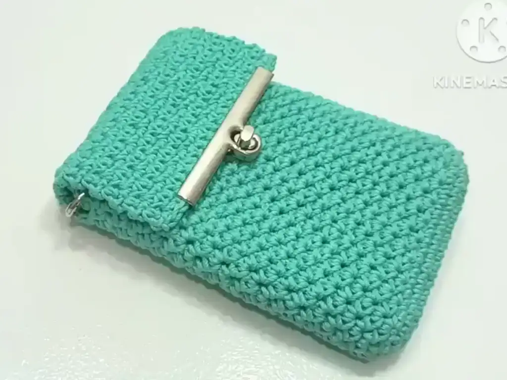 The finished crochet phone case with a metal clasp closure attached the flap, adding a secure and stylish element.