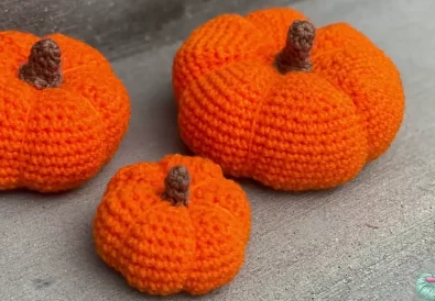 Three handmade crochet pumpkins in various sizes, perfect for fall decorating.