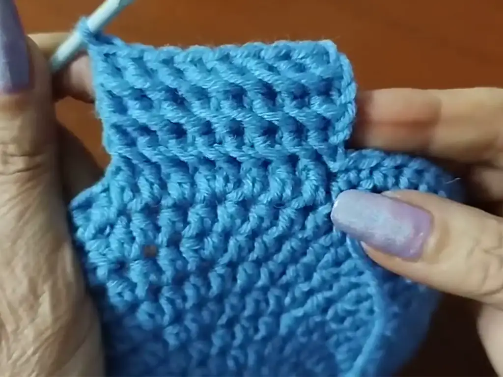 Crocheting a row of single crochet stitches along the edge of the body of the crochet cloche hat to create a smooth transition to the brim.