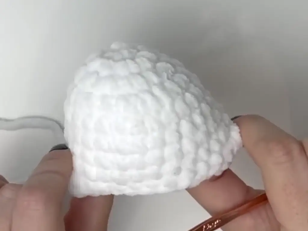 Partially completed crochet ghost head, showing the texture of the white chunky yarn.