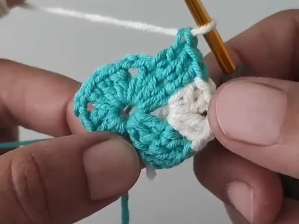 Row 3 of the Geometric Crochet Square showing the corner pattern, a repeating 2 dc, 2 ch, 2 dc sequence with color changes.