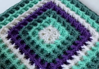 Colorful waffle stitch granny square on a white background.