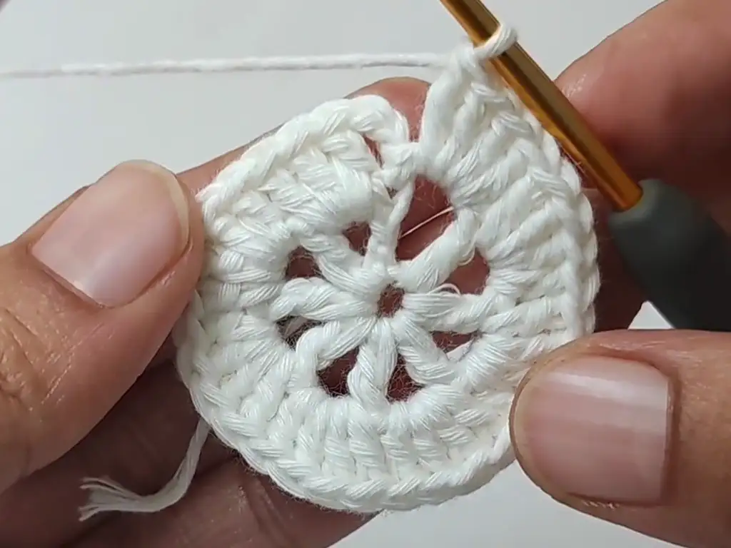 Working Round 5 of the crochet placemat pattern, creating chain spaces.