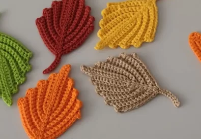Colorful crochet pumpkin leaves in various autumnal shades, perfect for fall decor.