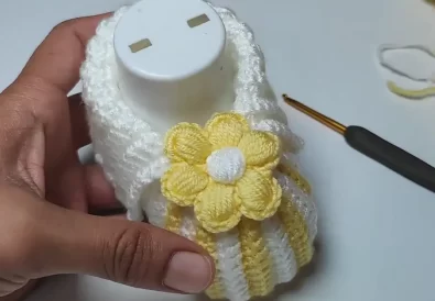 Finished crochet baby bootie with a flower embellishment.