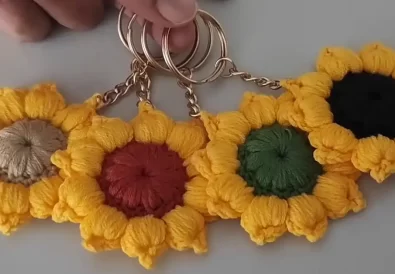 Five handmade crochet sunflower keychains with different colored centers, showcasing colorful variations of the pattern