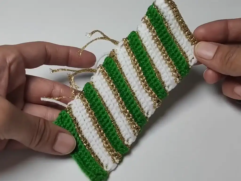 Completed crochet panel ready to be sewn together to form a Christmas ball keychain ornament. Easy DIY project.