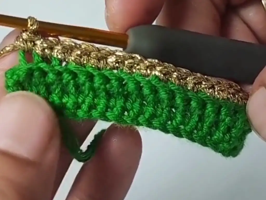 Adding a festive touch with gold glitter yarn.