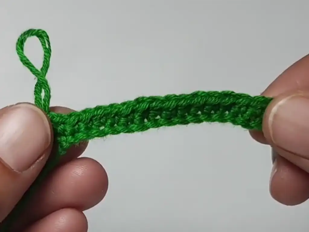 Working single crochet stitches in green yarn for the keychain.