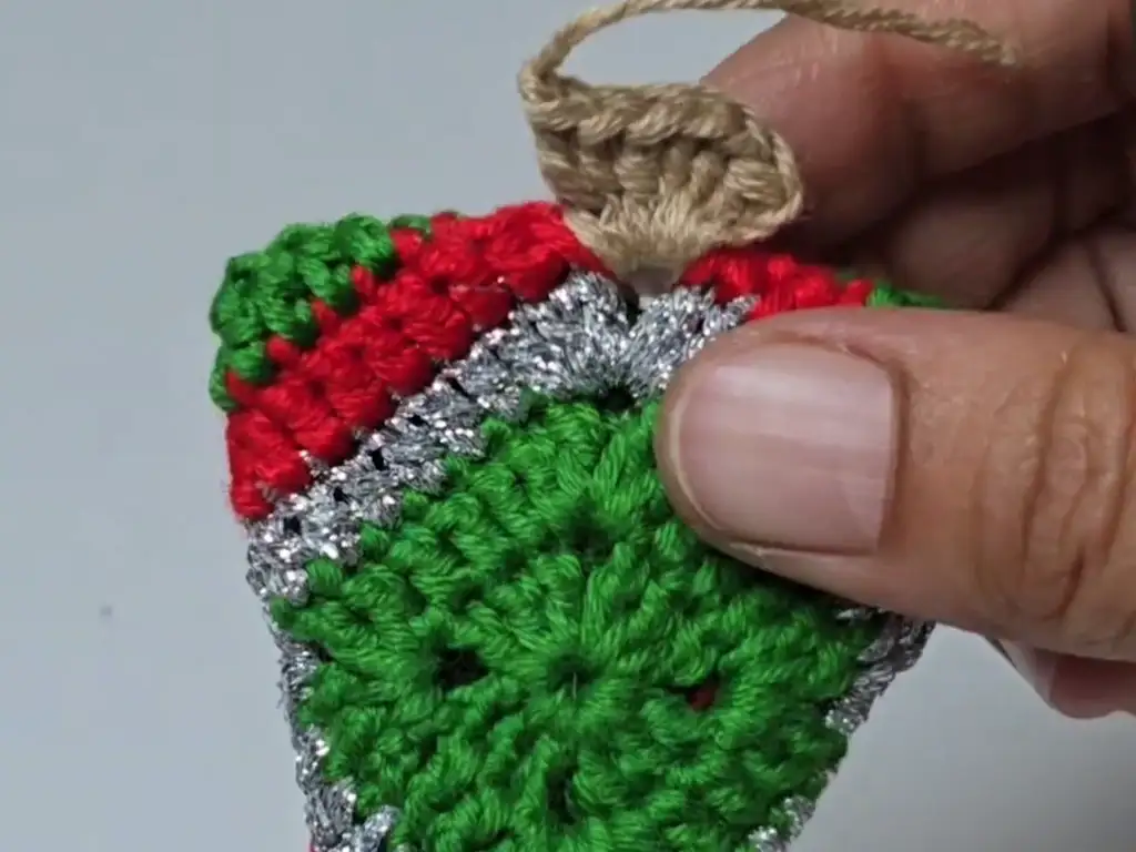 Adding the brown trunk to the base of the crochet Christmas tree ornament.