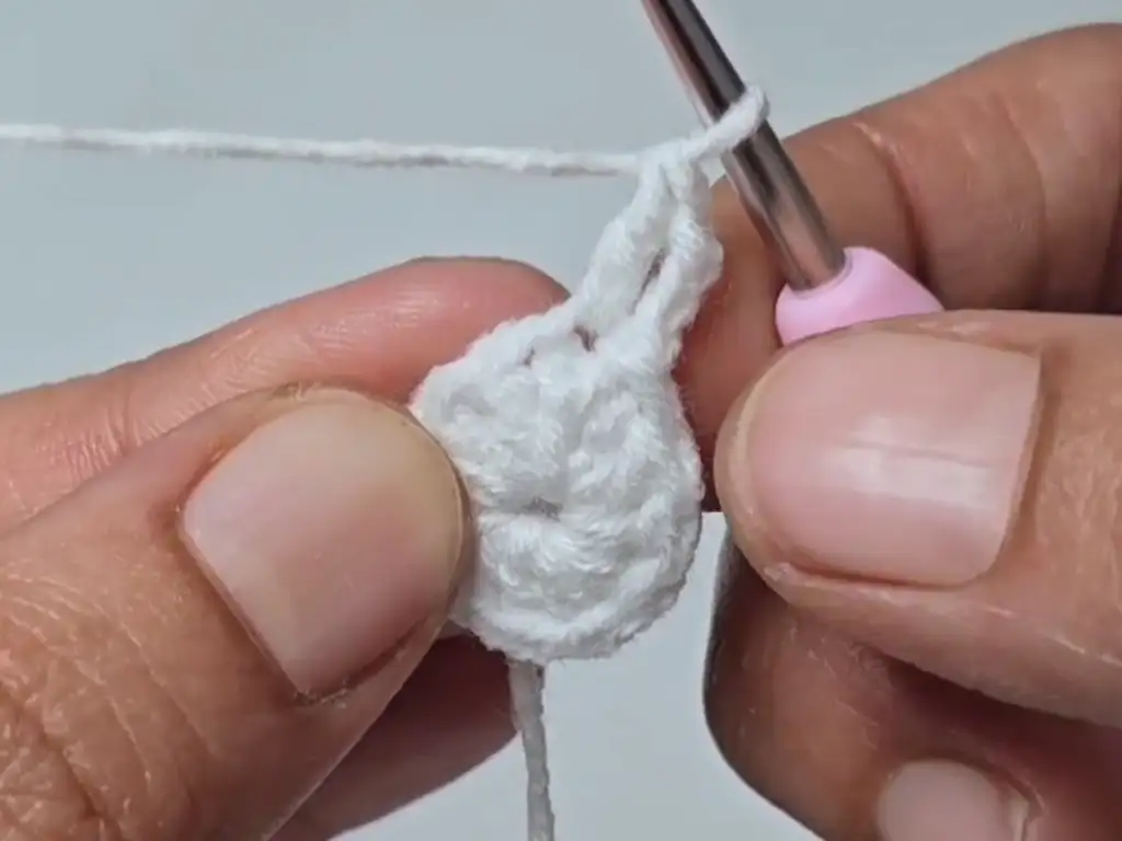 Continuing to crochet the snowman's head, showing the increasing size of the circle.