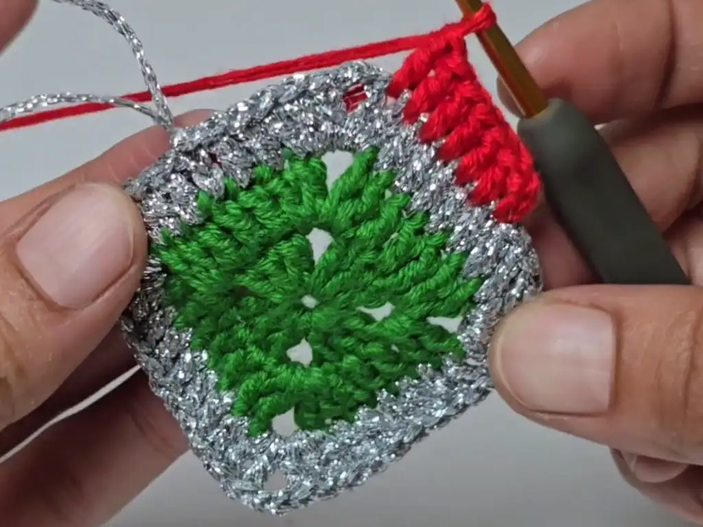 Adding the second color (red) to the crochet tree pattern, creating a striped effect.