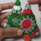 Two completed crochet Christmas tree ornaments, ready to hang.