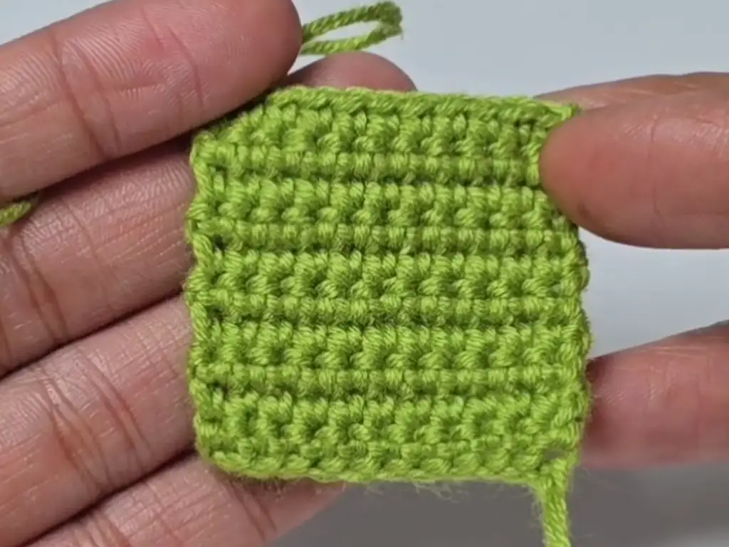 Completed small green crochet square.