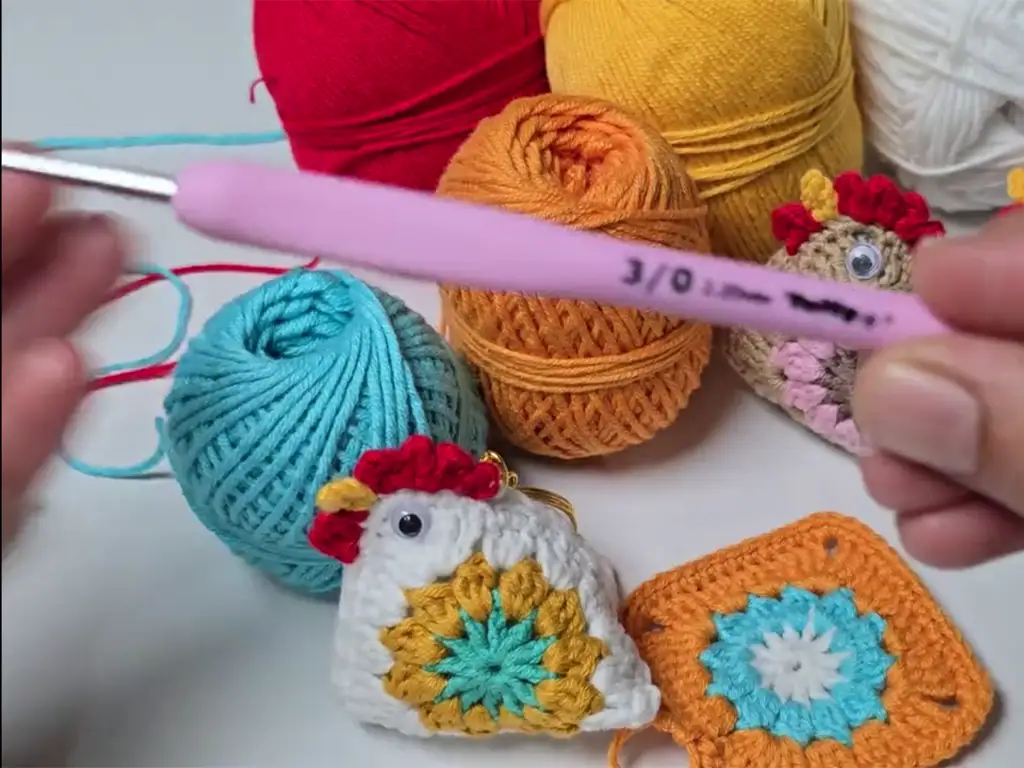 Crochet materials including yarn, hook, and completed keychains.