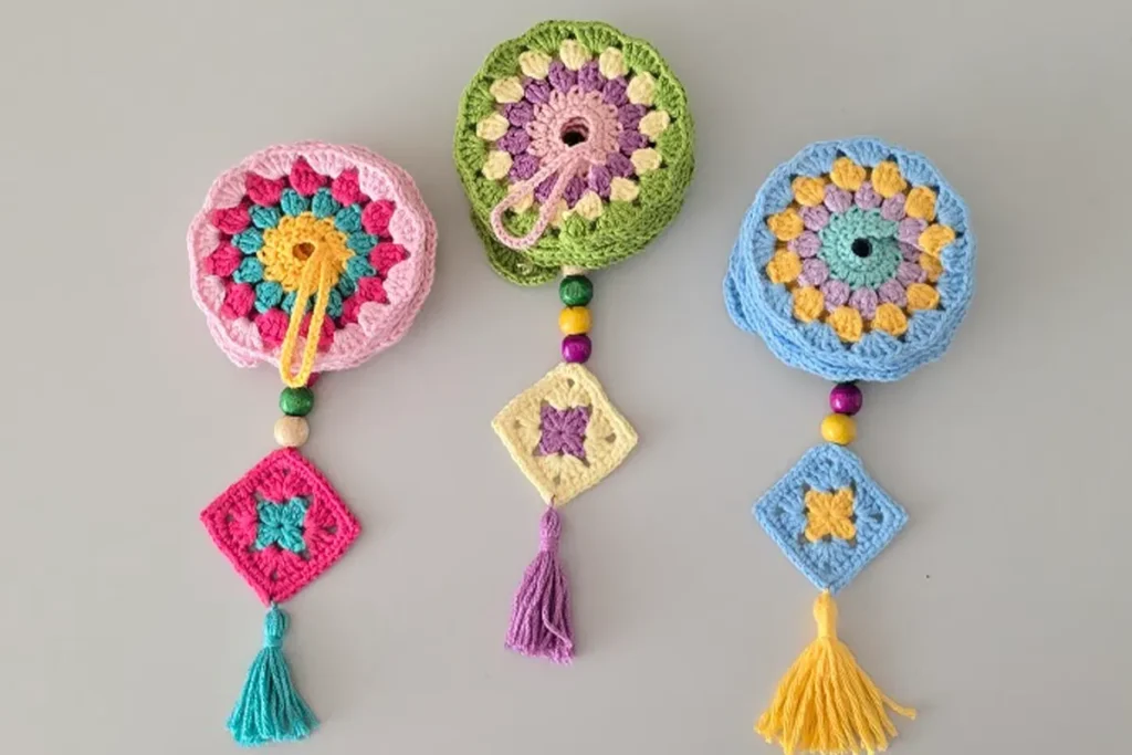 Crochet wind spinner with granny square ends and colorful beads, shown closed.