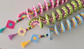 Colorful handmade crochet wind spinners fully opened, perfect for garden decor.