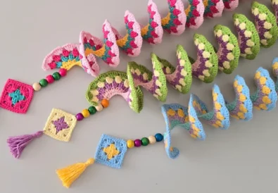 Colorful handmade crochet wind spinners fully opened, perfect for garden decor.