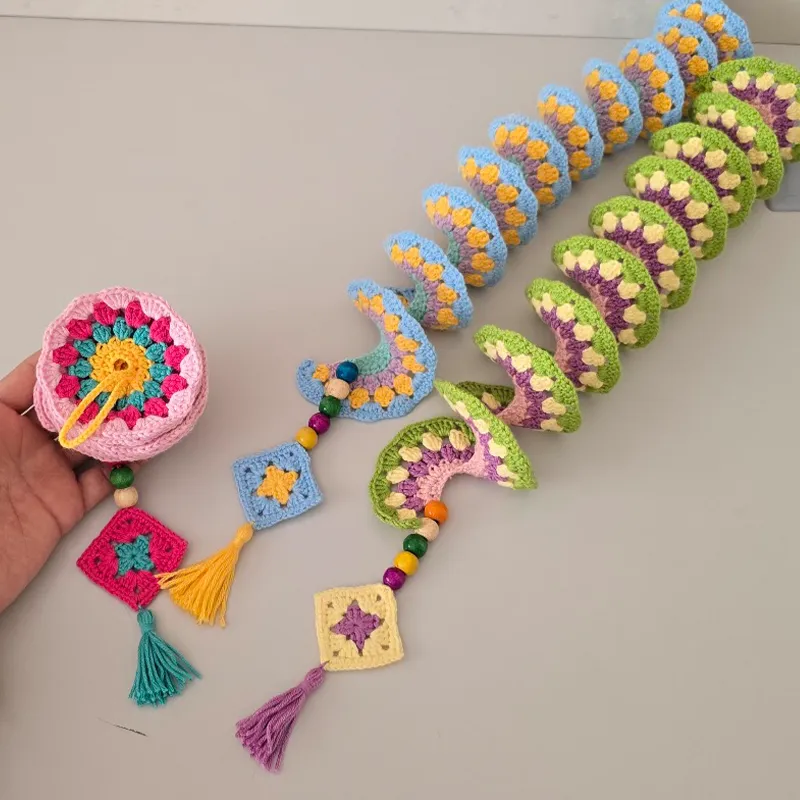Handmade crochet wind spinner held in hand to show size and shape.