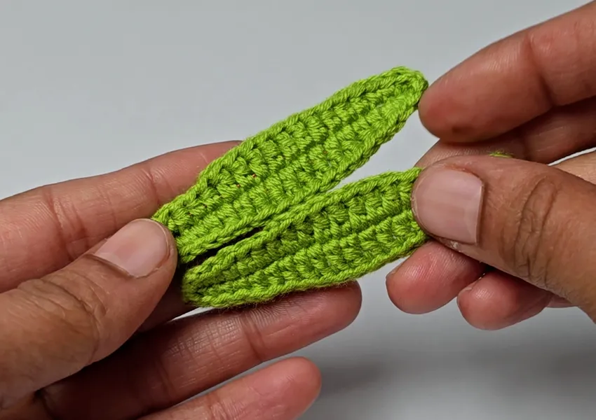 green crochet leaves for carnation flower shown in progress