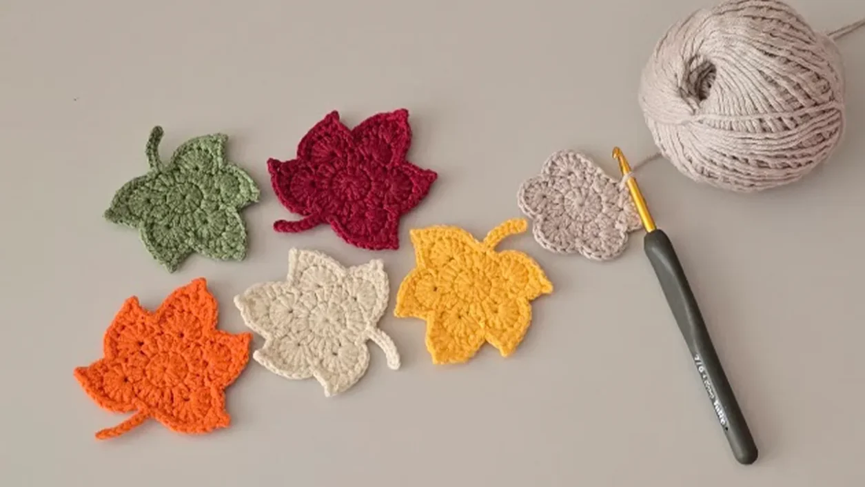 Crochet maple leaf pattern in autumn colors with yarn and hook.