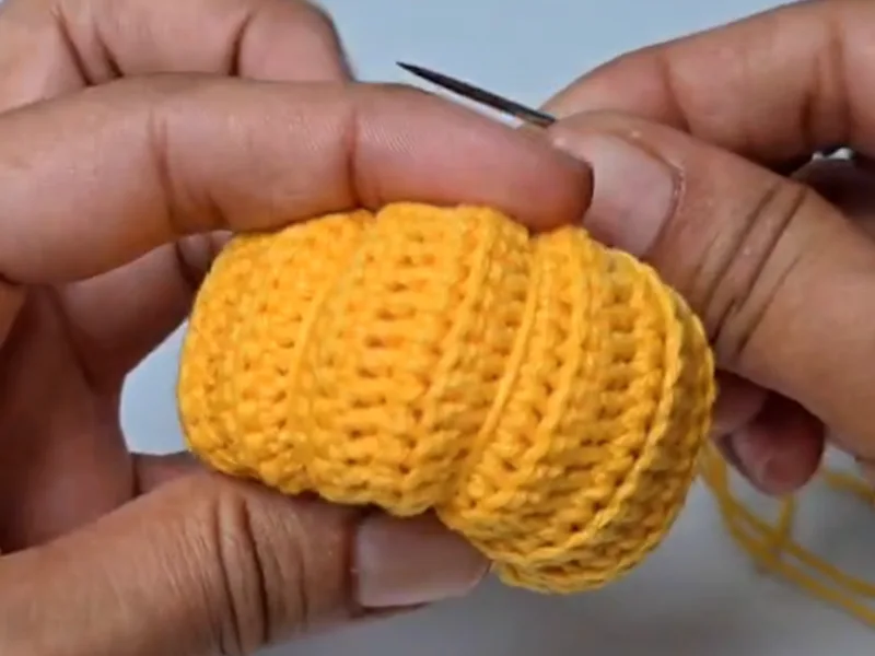 Creating ridges on crochet pumpkin keychain with tapestry needle