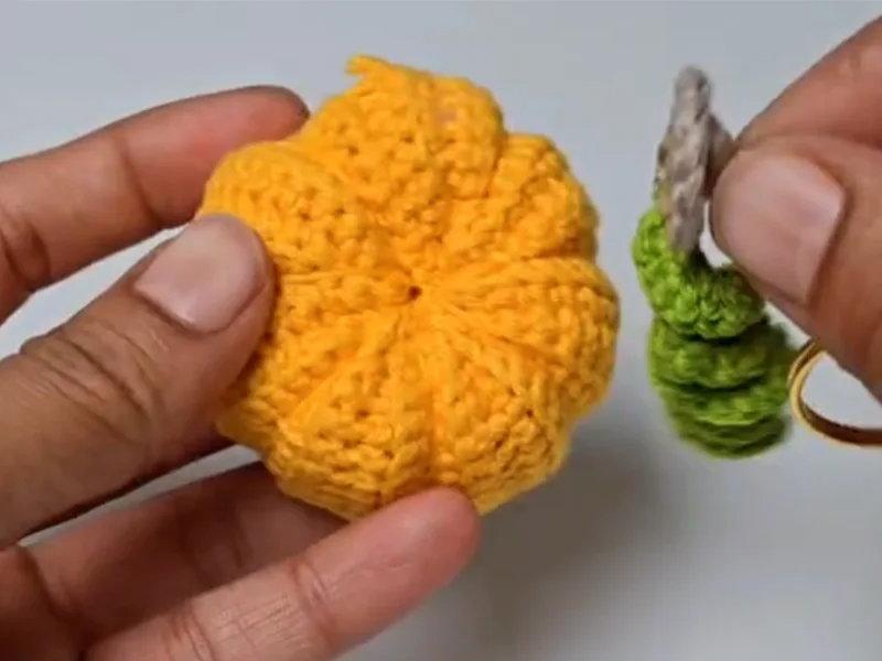 Attaching green stem to crochet pumpkin keychain top view