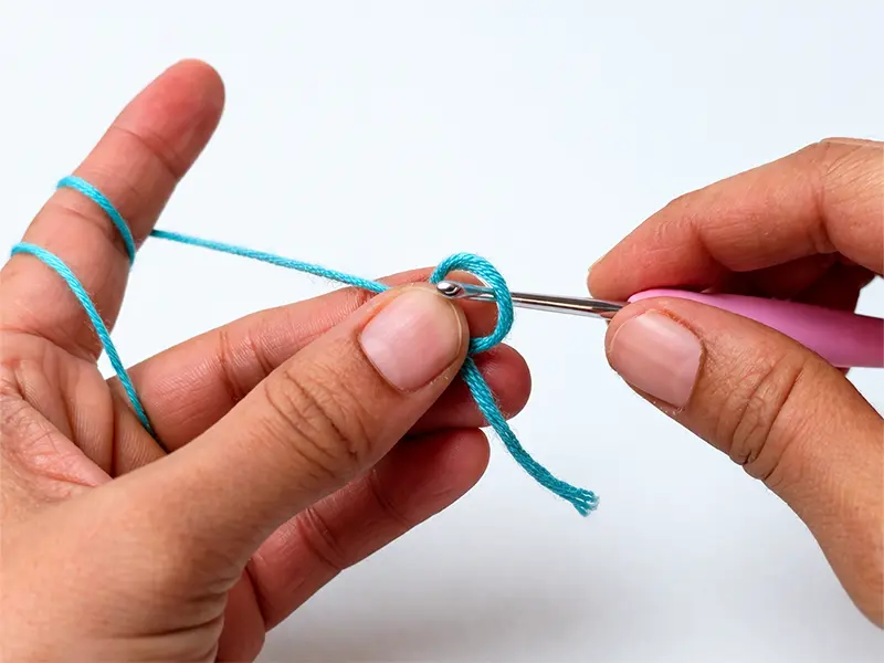 Crochet magic ring step for beginners using blue yarn and crochet hook