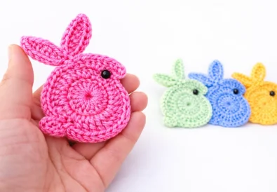 Easy crochet bunny applique for beginners held in hand with colorful crochet bunnies in background