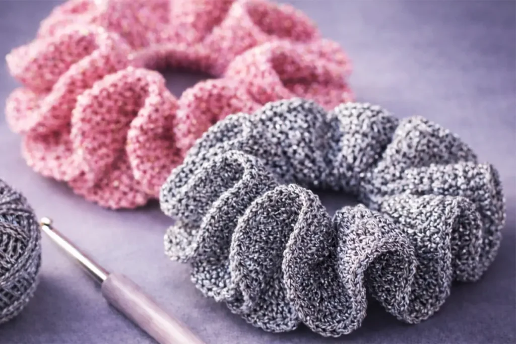 easy crochet scrunchie for beginners with pink sparkly yarn and ruffled texture close up