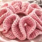 easy crochet scrunchie pattern for beginners made with pink sparkly yarn and ruffled texture